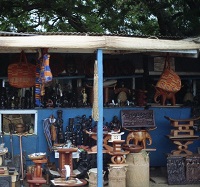 a tin roofed market stall of Ghanaian carvings