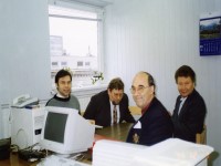 DevPar consultant smiles with 3 local consultants seated at a desk with a computer